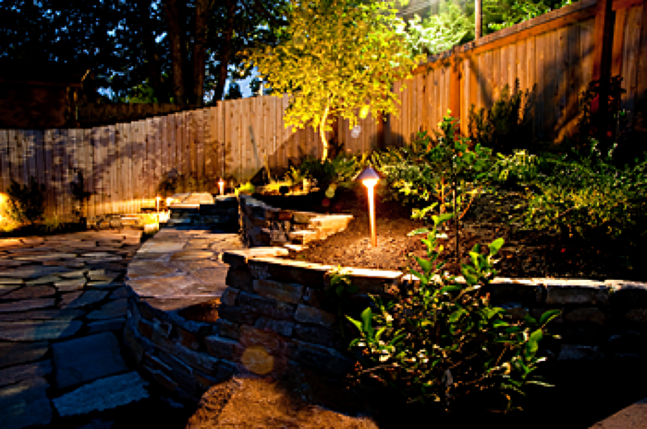 Illuminated garden path with stone steps.