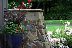 Stone planter with red and white flowers.