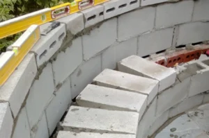 Curved concrete block wall under construction.