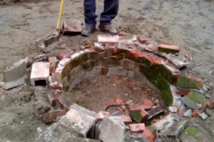 Broken brick structure on dirt ground.