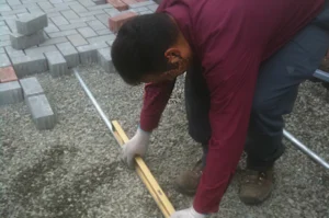 Worker leveling ground for paving stones.