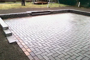 Brick patio with surrounding steps and grass.
