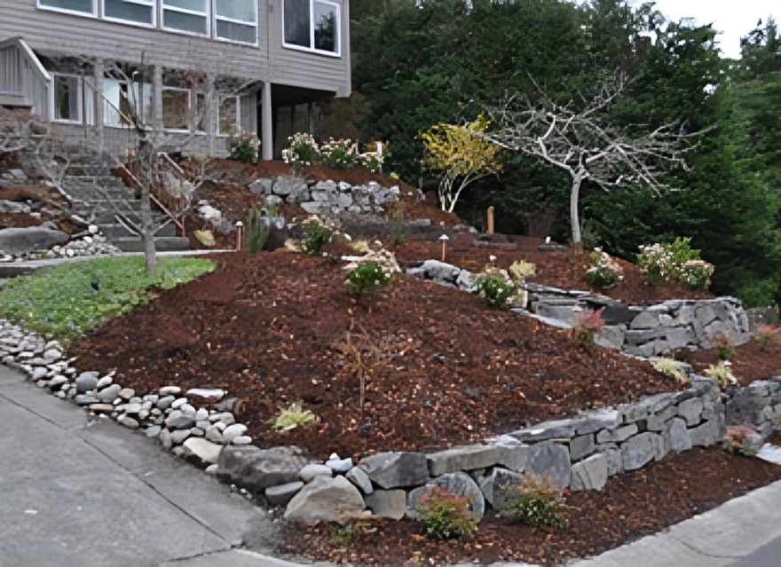 Terraced garden with stone walls and trees.