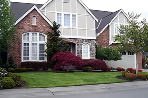 Brick house with manicured lawn and shrubs.