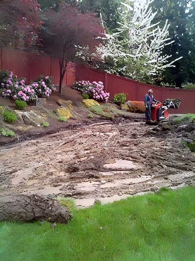 Garden landscaping with person operating machinery.